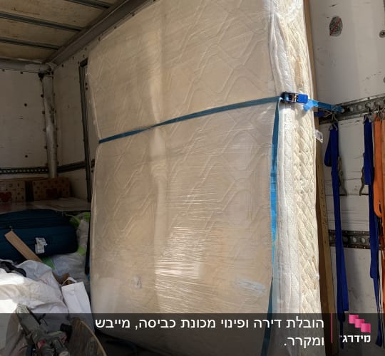 מזרן קשור בתוך משאית הובלה עם ציוד נוסף